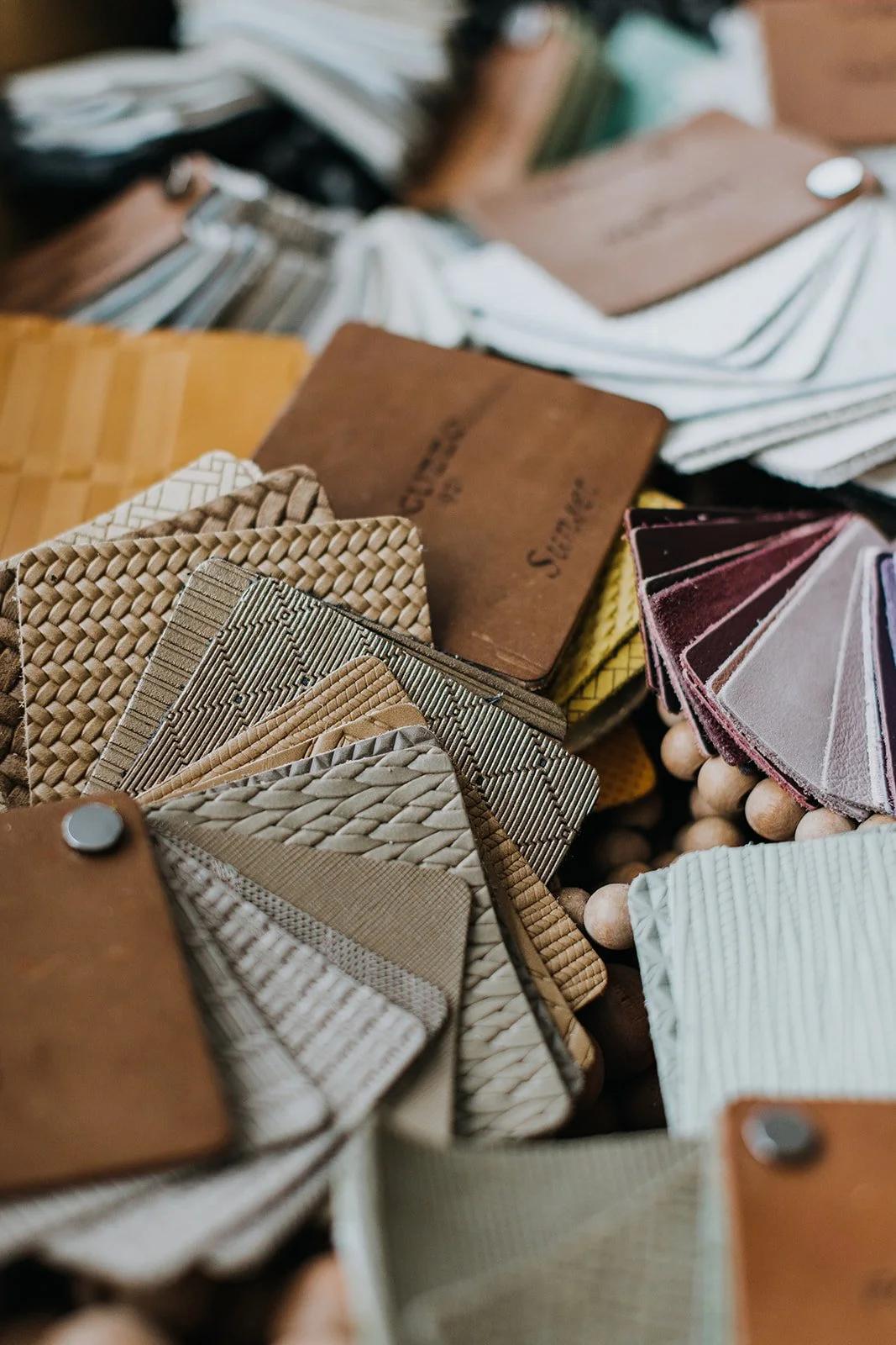 Leather, stone, tile and textile samples laid out on a work table during material selection